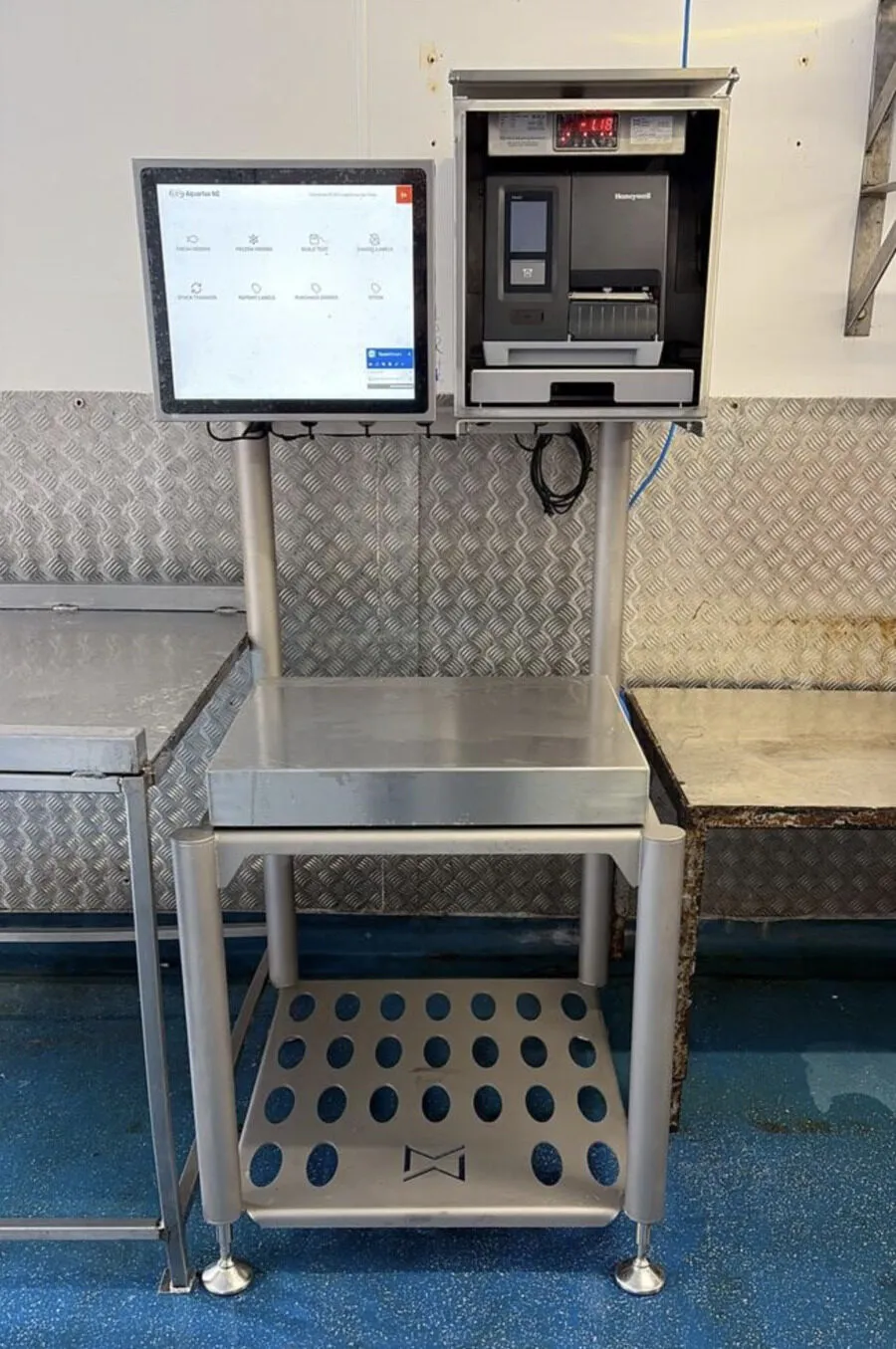 Aquarius weigh-label workstation in a fish factory: touchscreen, scale and label printer on a stainless steel stand
